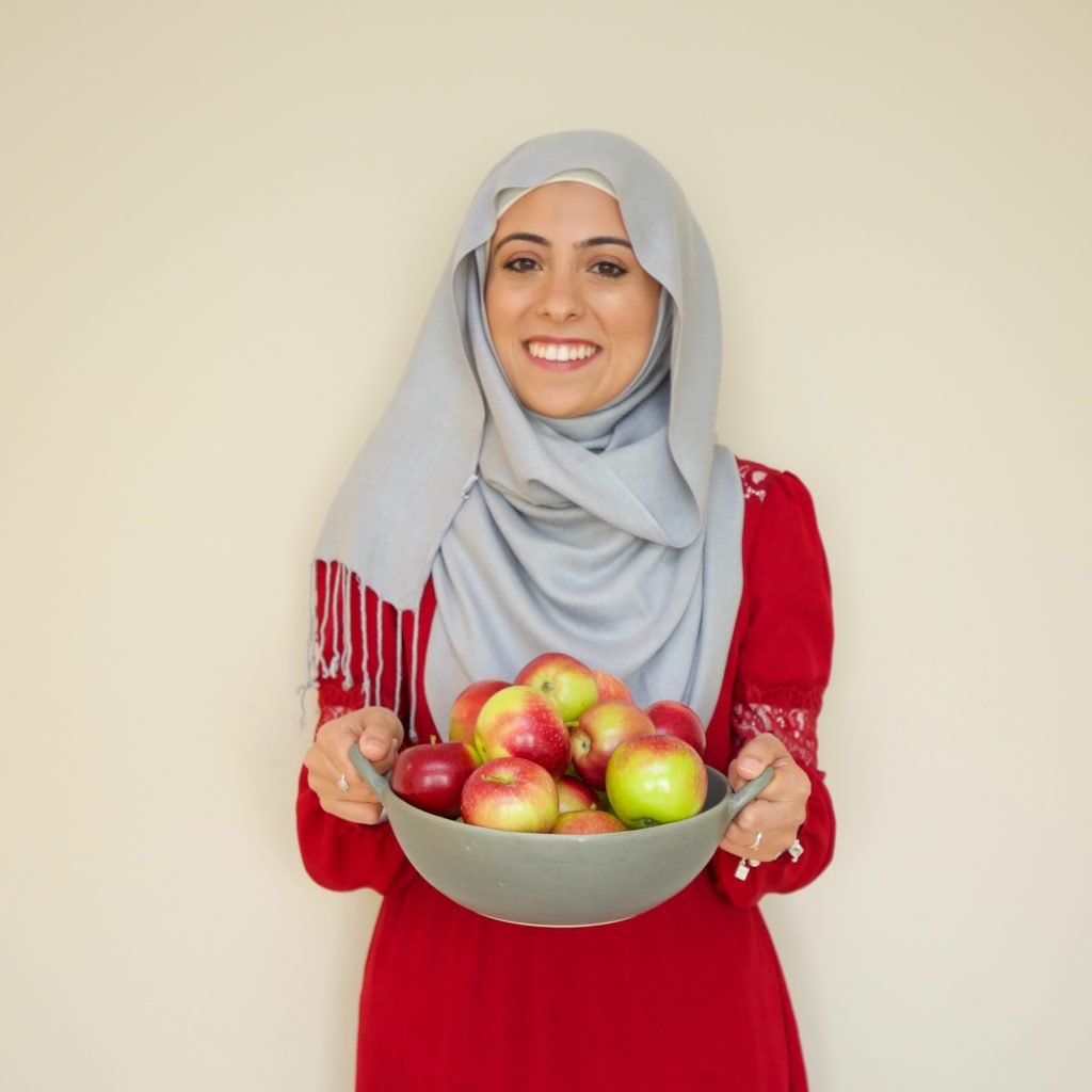 Bissan Ghaith, RD holding a bowl of apples