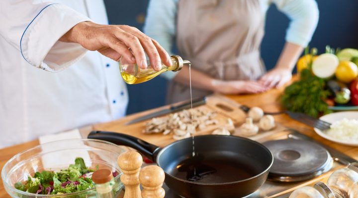 Chef pouring cooking oil on a pan